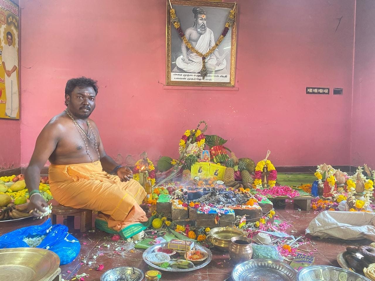 Offering into the homa kundam, with flowers, fruits and pooja vessels arranged around it
